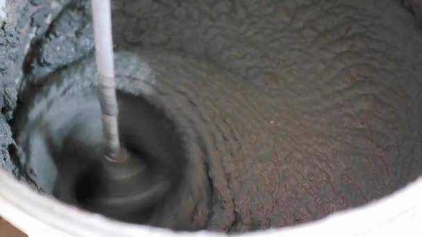 Grey mortar in bucket. mortar glue mixing in bucket by worker. construction — Stock Video