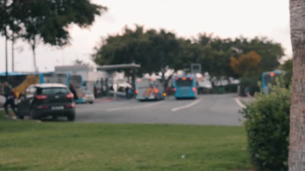Bus Station med bussar parkerade väntar på kunder. Suddig bild av stadens busstation i Paphos Cypern. Bil droppar person och lämnar från stationen. Transport — Stockvideo