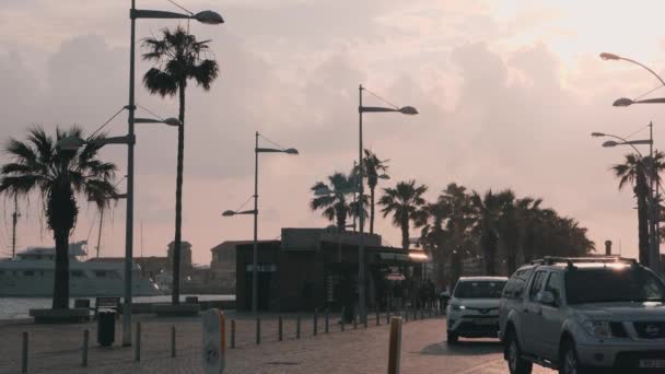 16 марта 2019 года / Кипр, набережная Пафоса с причалом для яхт в дождливую погоду. Береговая набережная с туристами и автомобилями. Люди идут через туристическую зону в Пафосе. Медленное движение — стоковое видео