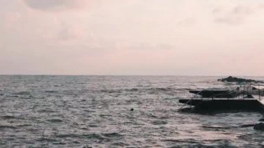 Fırtınalı denizde yüzen genç adam. Kötü rüzgarlı havada yüzen adam. Terk edilmiş gezinti ile fırtınalı deniz manzarası. Açık suda yüzen adam.