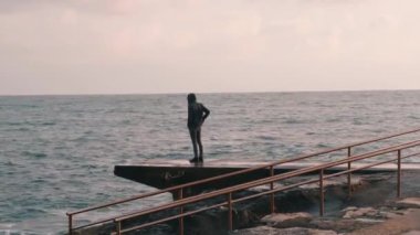 Fırtınalı denizin fotoğrafını yapan genç çocuk. İnsan okyanusun resmini çeker. Gezinti de duran yalnız çocuk