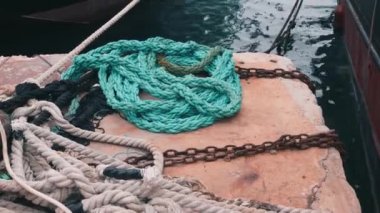 İskelede yatan mavi parlak olta takımı. Demirleme halatlarını kapatın. Marinada balıkçılık malzemeleri. Balık avlatisinin yakından bakisini. Tekne demirleme halatı