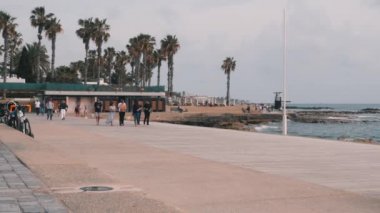 16 Mart 2019/Kıbrıs, Baf. Endonezyalı aile turistik gezinti ve tatil keyfini yürüyüş. Akdeniz sahili boyunca dolaşan turistler. Palmiye ve plaj alanı ile turistik bölge