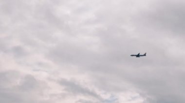 Gökyüzünde uçan bir uçak. Uçak havaalanına iniyor. Uçak inecek. Gökyüzünde mavi uçak. Jet gökyüzünde uçuyor. Kıbrıs adasına iniş uçağı. Gri gökyüzüne karşı yolcu jeti