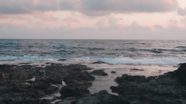 Θυελλώδης θάλασσα στο ηλιοβασίλεμα. Θέα των θαλάσσιων κυμάτων το σούρουπο. Τα κύματα του γαλάζιου ωκεανού χτύπησαν βραχώδη ακτή. Όμορφη βραχώδη ακτή. Τεράστια κύματα ωκεανού που συντρίβονται σε βράχους. Όμορφη θυελλώδης θάλασσα με βραχώδες θέα — Αρχείο Βίντεο