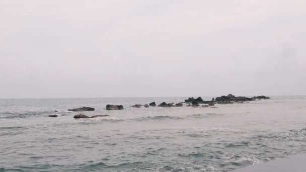 Hermosa vista de grandes rocas del océano. Las olas del mar se estrellan contra grandes rocas. Clima tormentoso del océano lluvioso. Vista de la playa rocosa. Mar Mediterráneo con mal tiempo lluvioso . — Vídeo de stock