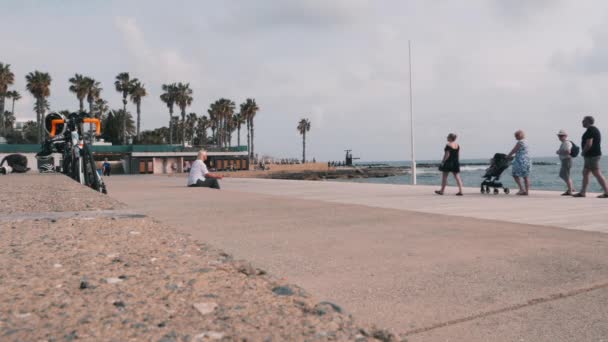 Mars 16, 2019/Cypern, Paphos. Livlig turist promenad med människor som går längs piren. Sommarsemester på stranden. Lycklig familj njuter semester nära havet. Gamla trevliga par som går på piren. — Stockvideo