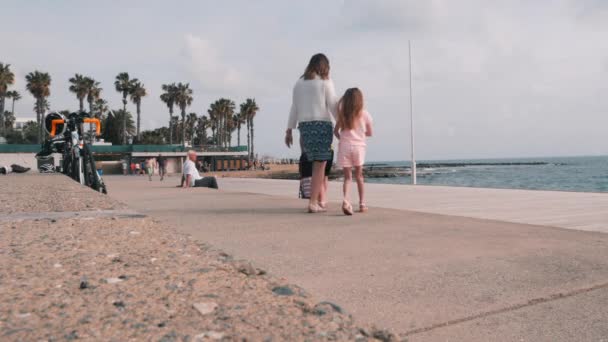 Mars 16, 2019/Cypern, Paphos. Lycklig familj med barn som går på piren. Trevligt lyckligt par promenerande längs stranden. Upptagen turist promenad — Stockvideo