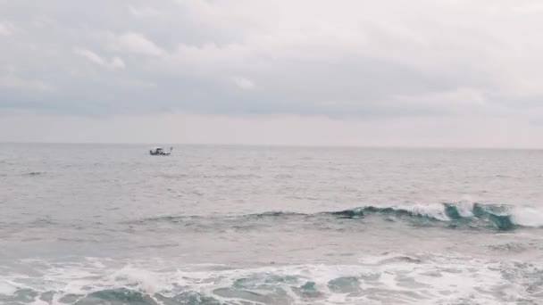 Pequeno barco de pesca solitário no mar. Velho pescador navegando em mar aberto. O homem está a pescar na tempestade. Navio de pesca balançando em ondas grandes. Pequeno barco balançando em mar aberto — Vídeo de Stock