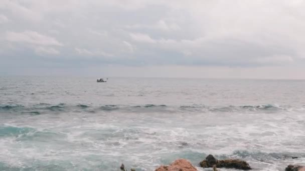 Ο άνθρωπος ψαρεύει σε βάρκα στη θάλασσα. Ψαράς σε βάρκα με καταιγίδα. Ο άνθρωπος ψαρεύει στην καταιγίδα. Μικρό πλοίο που πλέει σε ανοικτά νερά. Βροχερός καιρός στον ωκεανό — Αρχείο Βίντεο