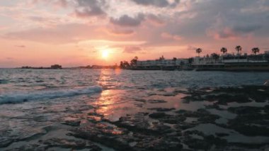 Gün batımında plaj kafeleri ve restoranları. Kayalık sahilde pembe gün batımı. Gezinti yolunda gün batımı. Güzel gün batımı. Pembe deniz gün batımı. Deniz gün batımı. Bulutlarla güzel pembe gökyüzü. Gün batımında güzel okyanus dalgaları
