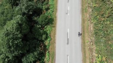 Genç kız yol bisikleti üst görünümünde sürüş kolaydır. Kadın triatlet bisiklet üzerinde sert eğitim den sonra kurtarma. Profesyonel kadın bisikletçi dağlarda yol bisikleti pedal.