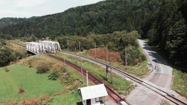 Profesyonel bisikletçi raylar arasında hızlı sürme. Karayolu bisikleti binici demiryolları ile yoğun bisiklet. Raylardan geçen bisikletçi ile demiryolunun havadan drone görünümü — Stok video