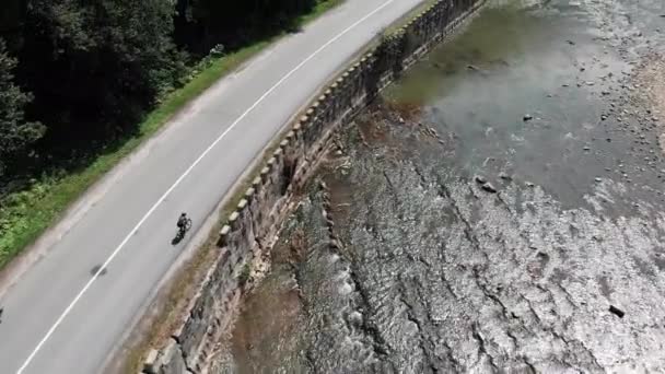 Vue de dessus de la formation de cycliste jeune femme sur vélo le long de la rivière. Femme motivée à vélo dans les montagnes. Jeune sportive professionnelle entraînement dur sur vélo le long de la forêt verte avec rivière — Video