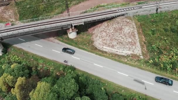 Mladý cyklista jezdí na rušné horské silnici s auty. Drone létá po horské krajině. Letecký pohled na Karpatské hory. Pohled na ukrajinskou krajinu — Stock video