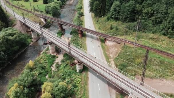 Fietsers rijden op racefietsen op trainingskamp in bergen. Top zicht op fietsers intensieve training op fietsen. Gemotiveerde jonge rijders trappen op fietsen langs de rivier. Fietsers rijden in de buurt van Railway — Stockvideo