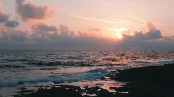 Bela noite crepúsculo no mar Mediterrâneo. Boa noite, pôr-do-sol. Raios cor-de-rosa de pôr do sol. Oceano tempestuoso com céu rosa e nuvens no fundo. O sol põe-se atrás das nuvens. Pôr-do-sol inesquecível — Vídeo de Stock