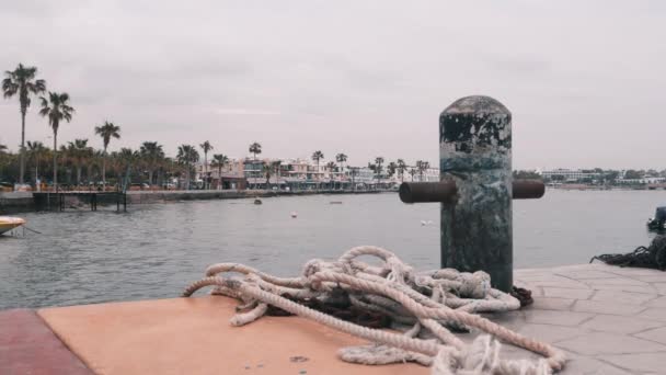 Close up of white mooring rope. Fish-tackle at marina. Beautiful view of tourist promenade from marina.  Close up of mooring berth. Sea mooring pillar.  Side view of pier at mediterranean sea. — Stock Video