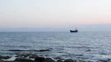 Eski paslı gemi denizde mahsur kaldı. Deniz manzarasının güzel manzarası. Deniz, eski gemi yle mahsur kaldı. Yağmurlu bir günde güzel deniz manzarası. Büyük gemi kayalık kıyıya yakın demirledi.