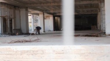 İnşaatçı şantiyede çalışıyor. İşçi kaynak oluyor. İnşaat çıtası ile