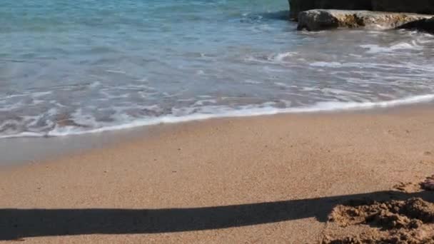 Vue rapprochée des jeunes pattes femelles sur le rivage sablonneux. Vue rapprochée de belles jambes féminines sur la mer. Gros plan des jambes féminines marchant sur le sable. Traces de pieds féminins sur du sable. Fille vient dans l'eau . — Video