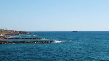 Kayalık sahilin yan görünümü. Güzel deniz manzarası. Kayalık plaja vuran deniz dalgaları.