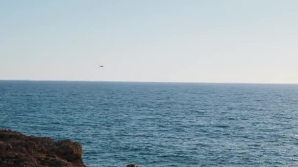 Hubschrauber fliegen über dem Meer. Hubschrauber fliegt über Wasser. Hubschrauber fliegt am Horizont. Hubschrauberflug — Stockvideo