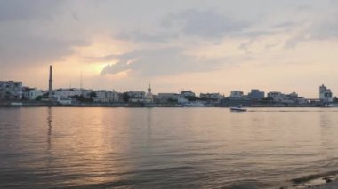 Önünde nehir olan sanayi şehir merkezinde güzel gün batımı. Köprü ve fabrika ile sanayileşmiş şehirde pembe gün batımı