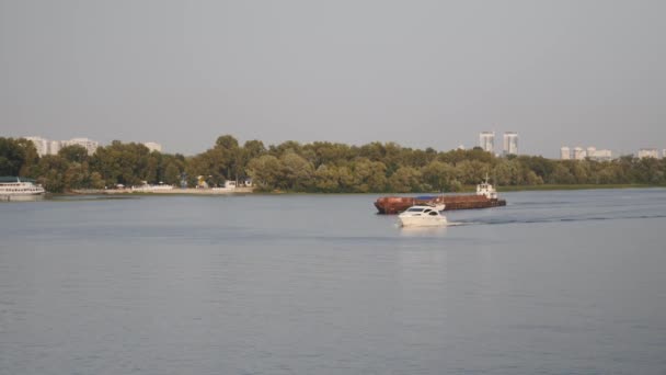 Krásná bílá jachta plující na řece. Malá bílá loď a starý rezavý člun na řece. — Stock video