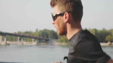 Siyah spor giyim profesyonel erkek koşucu sabah çalışır. Şehir rıhtımında koşan ince aktif çocuk. Açık hava egzersizleri yapan genç adam. Uygun sportif adam nehir boyunca koşu. Yavaş çekim