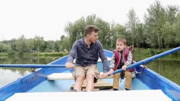 Papá feliz divirtiéndose al aire libre con su bebé. Feliz familia joven pasar tiempo fuera. Relación padre e hijo. Precioso padre e hijo navegan en barco y descansan al aire libre . — Vídeos de Stock