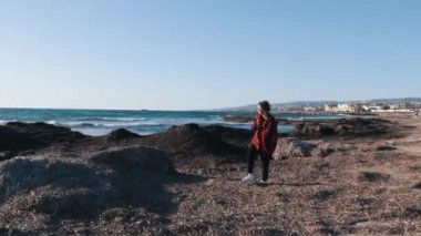 Ekose kırmızı gömlekli melankolik üzgün kadın denizin boş kıyısında yürüyor. Genç yalnız kadın sahilde yalnız vakit geçirir. Kötümser beyaz esmer kadın ufka bakıyor ve iç karartıcı.