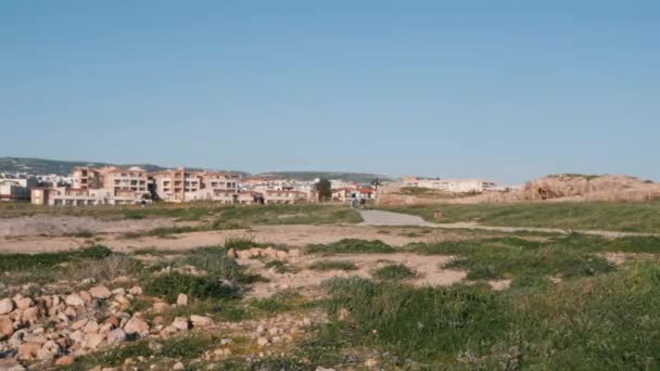 Muelle turístico de Paphos con hoteles en el horizonte. Vista aérea del paseo peatonal con ruinas. Drone plano de zona turística con gente caminando — Vídeos de Stock