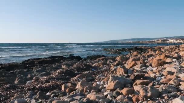 Basura sintética y plástica en playa rocosa de mar mediterráneo. Concepto de problema de contaminación ambiental. Contaminación ambiental en el mar. Problema ecológico. Vista aérea de la playa con basura — Vídeo de stock
