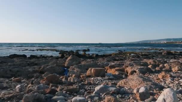 Basura plástica en playa de mar mediterráneo. Drone vista de la basura cerca del mar. Concepto de problema de contaminación ambiental. Contaminación ambiental en el mar. Problema ecológico. Basura de plástico ensuciando rocas — Vídeo de stock