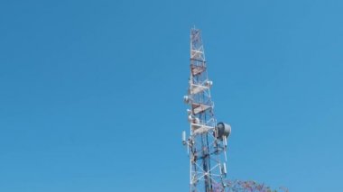 Radyo, televizyon ve mobil iletişim kulesi mavi berrak gökyüzüne karşı. Arka planda mavi gökyüzü ile telekomünikasyon kulesi