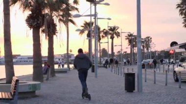 21 Mart, Baf, Kıbrıs Gün batımında palmiye, kafe ve restoranlar ile Canlı turistik gezinti. Yaya rıhtımında pembe günbatımı