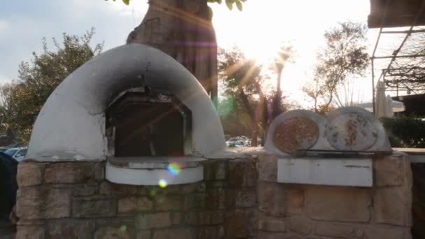 Vue latérale du poêle en béton blanc sur la rue par la terrasse d'été du restaurant — Video