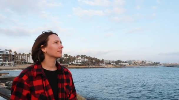 Eenzame jonge brunette vrouw genieten van vakantie aan zee. Triest aantrekkelijk vrouw wandelen langs de kust bij zonsondergang. Close-up weergave — Stockvideo