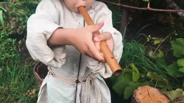 Little children's fingers playing on wooden music instrument, close up view. Baby fingers trying to play on flute — Stock Video