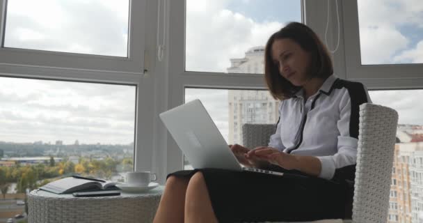 Jeune femme d'affaires concentrée dans des vêtements stricts assis dans un bureau moderne avec ordinateur portable et en attente de réponse, contrarié et en colère de perdre affaire avec des partenaires — Video