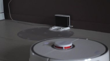 Robot elektrik süpürgesi temizlikten sonra şarj olmak için kenetlenme istasyonuna dönüyor. Robotik elektrik süpürgesi yükleme istasyonuna gidiyor.