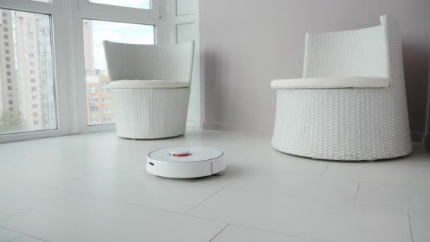 Robot vacuum cleaner tidy up on the balcony. Robot cleaner cleaning the tile flooring in the room — Stock Video