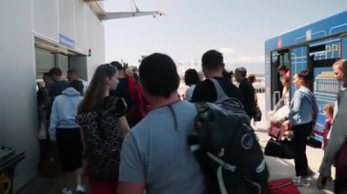 Boryspil / Ukrayna - 19 Temmuz 2019 - Bir grup turist nakil otobüsünden inip havaalanına gitti. Farklı uyruklu insanlar havaalanında yolcu aktarma otobüsünden iniyorlar.