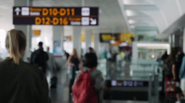 Havaalanının bulanık manzarası. Havaalanında bekleyenler var, uçuş için bekleyen insanlar var. Geçit bilgi masası kalkış alanında. Uçak kalkış alanı
