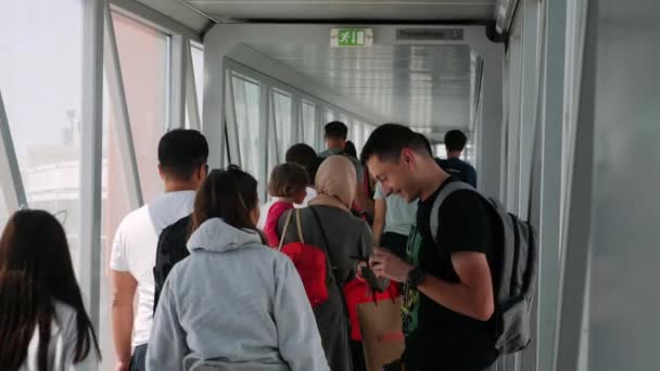 Boryspil / Ukrajna-Július, 19 2019 - boldog turisták megy át a repülőgép közlekedőfolyosón Boryspil repülőtér. Repülőre szálló utazók — Stock videók