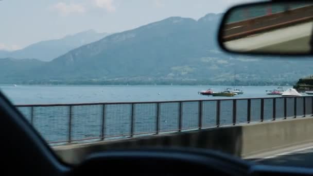 Όμορφη λίμνη και βουνά τοπίο από το αυτοκίνητο. Car οδήγηση κατά μήκος όμορφη λίμνη βουνό με πολυτελή γιοτ και βάρκες. — Αρχείο Βίντεο