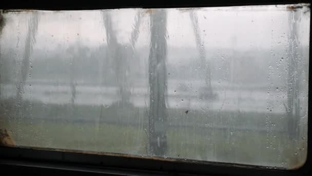 Gotas de lluvia en el vaso. Condensación de gotas de agua en el vaso. Gotas de agua cayendo sobre vidrio. Lluvia corriendo por la ventana del tren. Temporada de lluvias — Vídeos de Stock