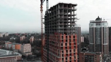 İnşaat vinci inşaat alanında. Tuğla beton bina, hava aracı manzaralı. Tamamlanmamış yüksek katlı ev