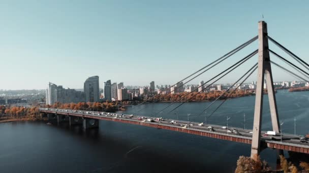 Şehir merkezinde nehir boyunca beton köprü var. Köprüde yoğun arabalar, hava aracı görüntüsü. Metropolis 'in iki yakasını birbirine bağlayan köprü. Kyiv, Ukrayna — Stok video